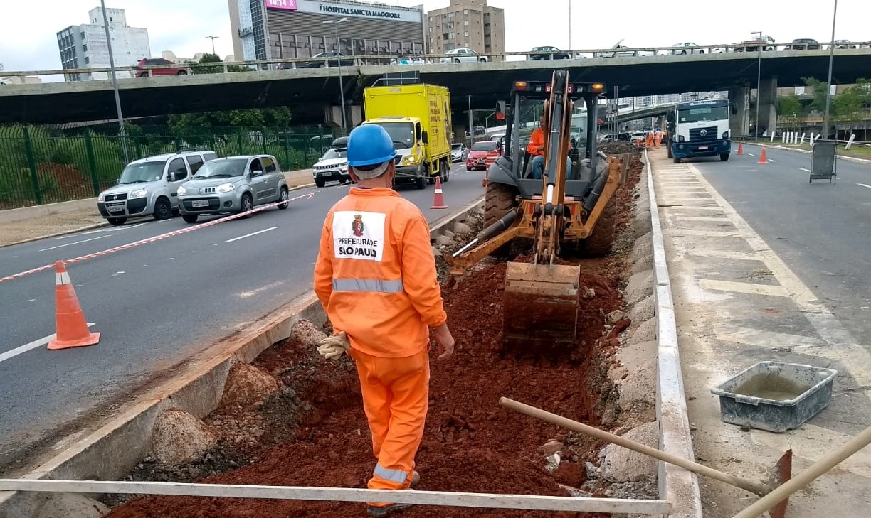 Foto da máquina cavando no jardim de chuva na Avenida do Estado